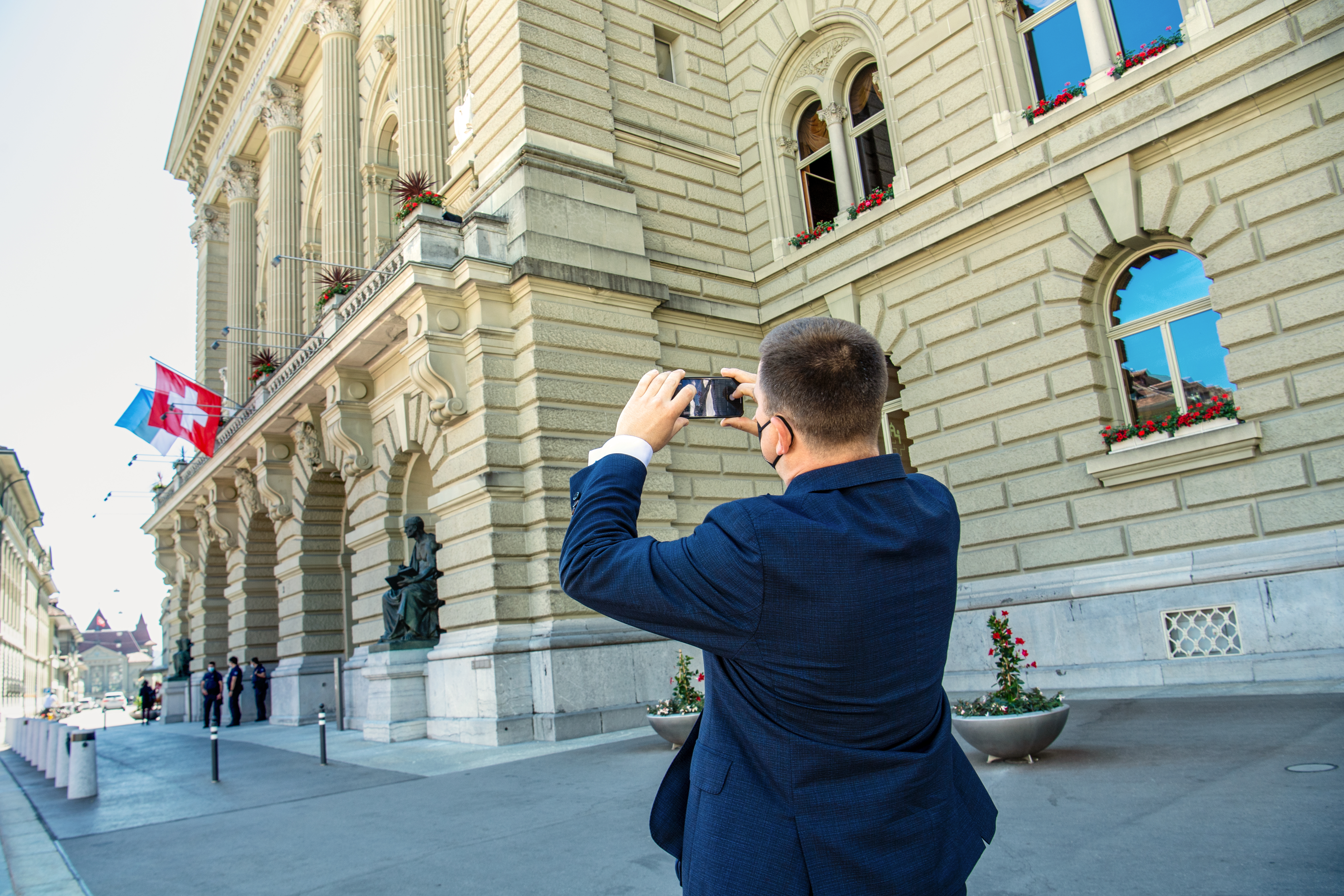 Der estnische Parlamentspräsident Jüri Ratas beim Fotografieren der Fahnen der Schweiz und der estnischen Republik am Parlamentsgebäude 